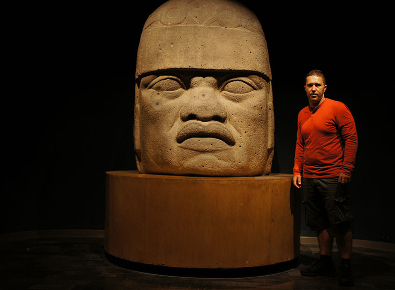 Pored olmečke glave u Antropološkom muzeju u Mexico Cityu, Meksiko 