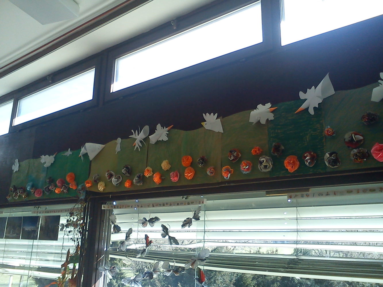 Cvjetna livada: podloga je pak-papir obojen pastelom, ptice su od bijelog papira, a cvjetovi od papira iz časopisa [drugi razred]
